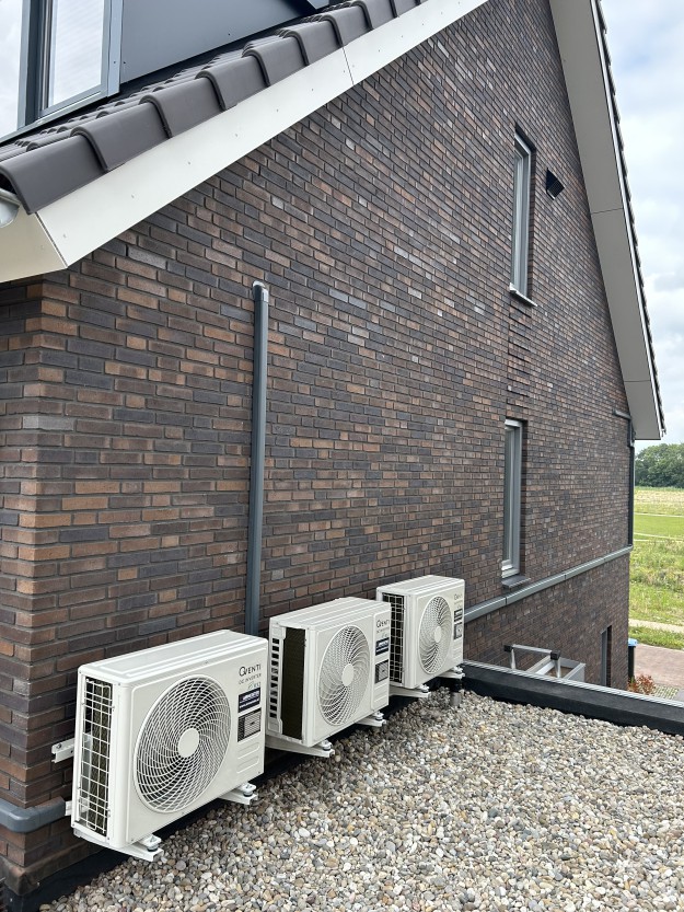 Airconditioning units bij bakstenen huis.
